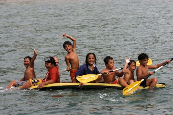 Local children play on Capaz's inflatable kayak.
